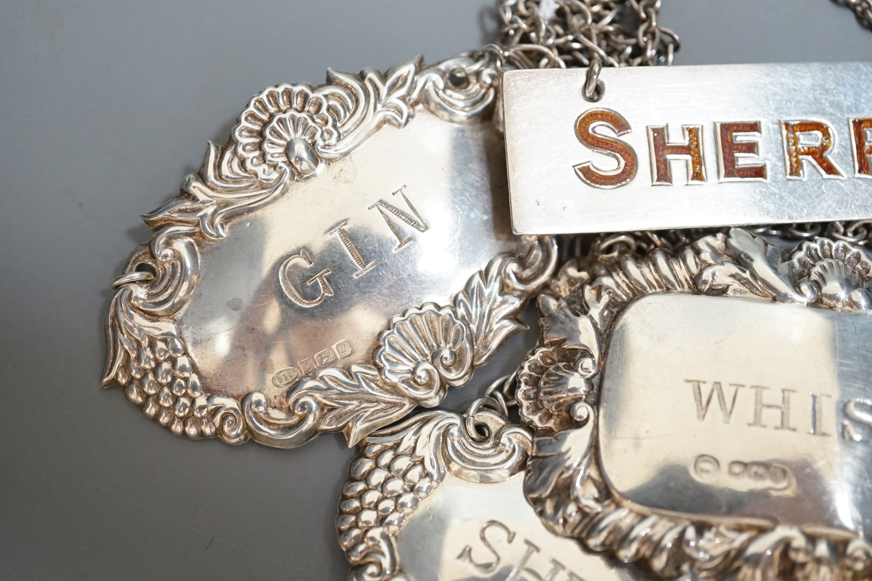 Four assorted modern silver wine labels including enamelled Sherry.